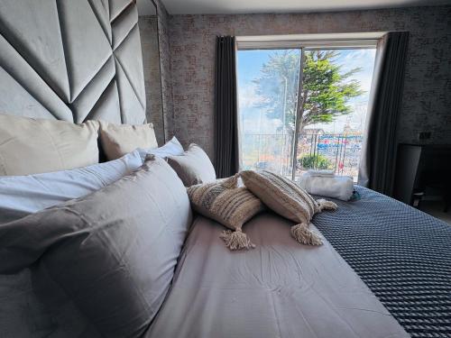 a bedroom with a large bed with a large window at Pacific Hotel in Clacton-on-Sea