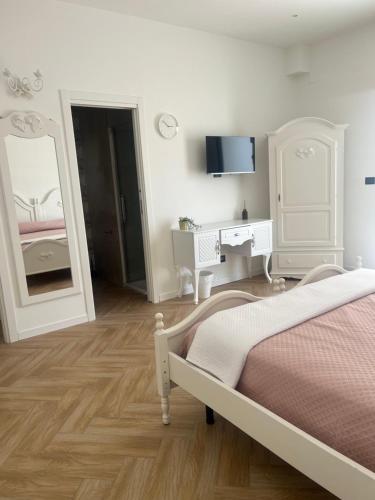 a bedroom with a bed and a dresser and a mirror at affittacamerecoppola in Angri