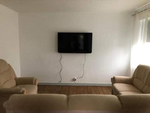 ホスにあるRooms in Krusåのリビングルーム(ソファ2台、壁掛けテレビ付)