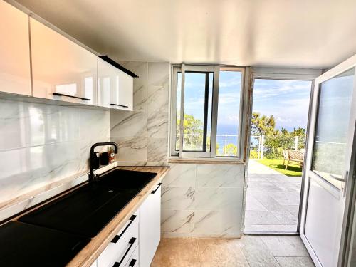 a kitchen with a sink and a large window at Villa Naïma Esterel in Saint-Raphaël