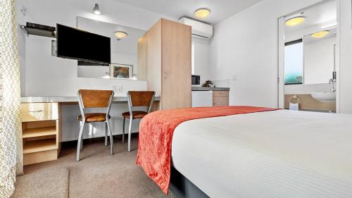 a hotel room with a bed and a kitchen at Bella Vista Motel Rotorua in Rotorua