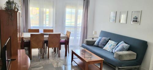 a living room with a blue couch and a table at Apartamento Sabimar Playa in San Luis de Sabinillas