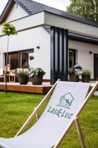 a sign sitting in the grass in front of a house at Domek Las&Luz Moszna in Moszna