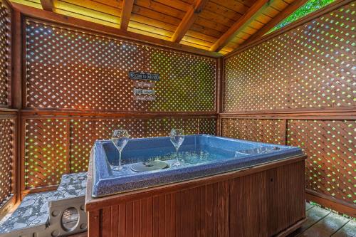 a jacuzzi tub in a room with a washing machine at Escape to the Smokies- Pool, hot tub, cozy cabin, Pigeon Forge in Pigeon Forge