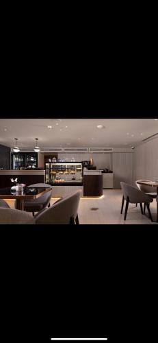 a large kitchen with tables and couches in a room at Emmanuel suits in Eilat