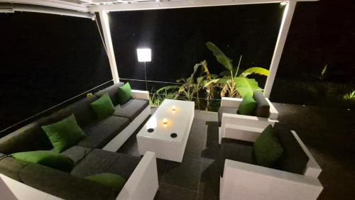 a rooftop patio at night with a couch and a table at Wonogiri Rocks in Tempuran