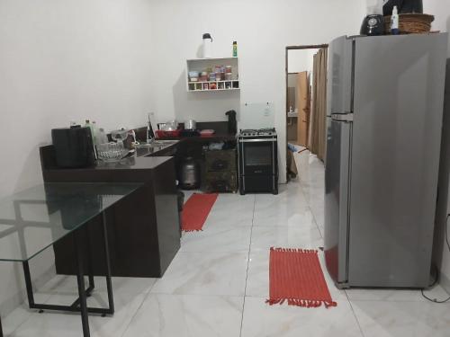 una cucina con un frigorifero in acciaio inossidabile in una stanza di Recanto Curva das dunas -Lençóis maranhenses a Santo Amaro