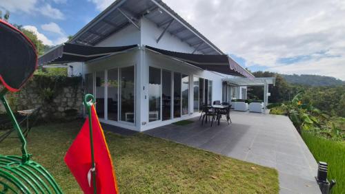 a white house with a patio with tables and chairs at Wonogiri Rocks in Tempuran