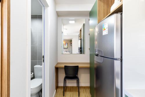 a small bathroom with a chair and a refrigerator at BSR Luxe Studio next to Allianz Park w Rooftop Pool and Pet Friendly in São Paulo