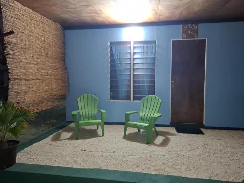 two green chairs in a room with a window at Xavier Rangiroa Lodge in Avatoru