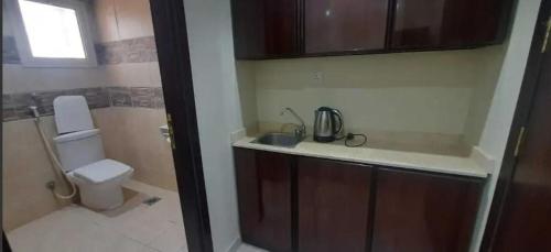 Un baño pequeño con inodoro y lavabo. en فندق البركة, en Al Hindāwīyah