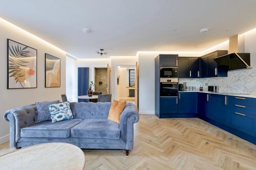 a living room with a blue couch and a kitchen at Modern apartment in town centre in Oban