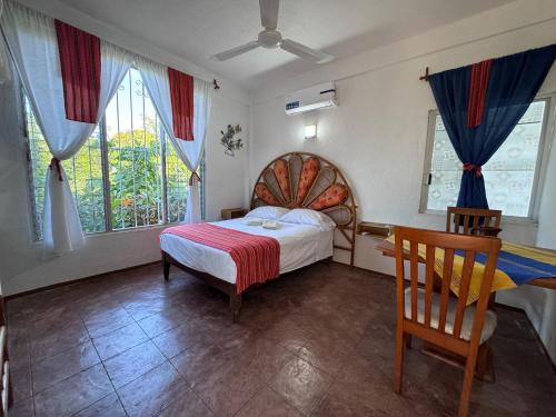 a bedroom with a bed and some windows at Casa Icaco in Puerto Escondido