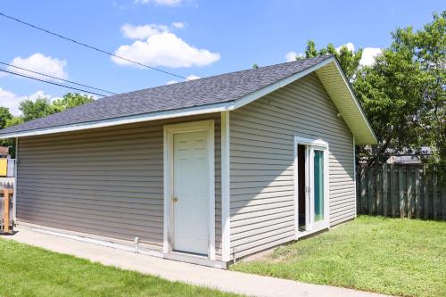 a small shed with a white door in a yard at Walk To Beach And Downtown Lake Geneva! in Lake Geneva