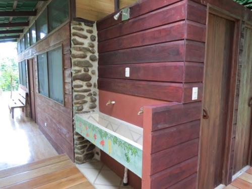 a wooden wall with a bench in a house at Vocaré Finca Agroecológica in Upala