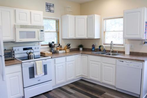 a kitchen with white cabinets and white appliances at Walk To Beach And Downtown Lake Geneva! in Lake Geneva