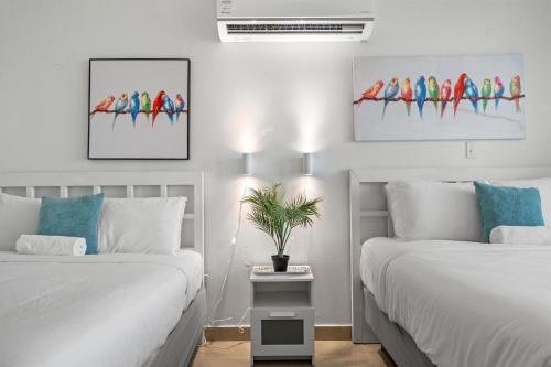 a bedroom with two beds and a painting on the wall at Condado Lagoon by Otium in San Juan