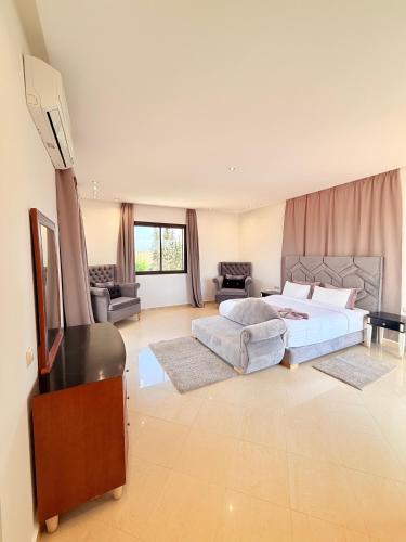a large bedroom with a bed and a flat screen tv at Villa Patel in Marrakech