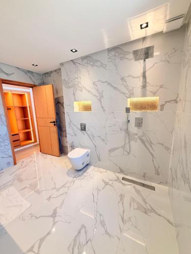 a bathroom with marble walls and a toilet at Villa Patel in Marrakech