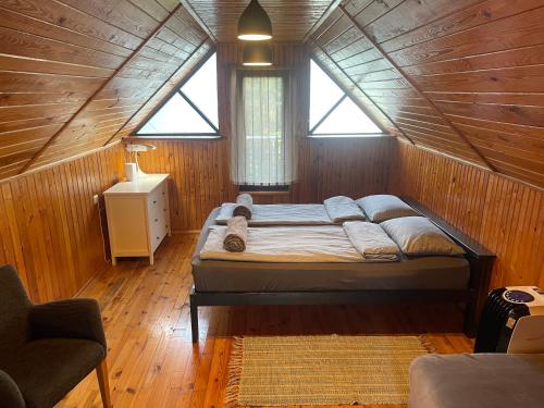 a bedroom with a bed in a wooden room at Summer holiday house Vizuli in Bernāti