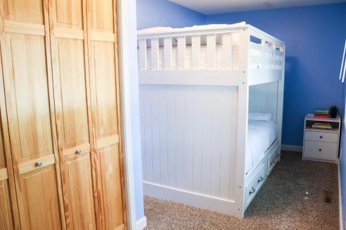 a white bunk bed in a room with blue walls at Walk To Beach And Downtown Lake Geneva! in Lake Geneva