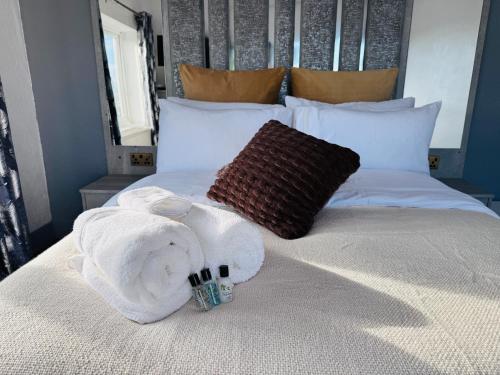 a bed with a towel and two bottles of alcohol at Pacific Hotel in Clacton-on-Sea