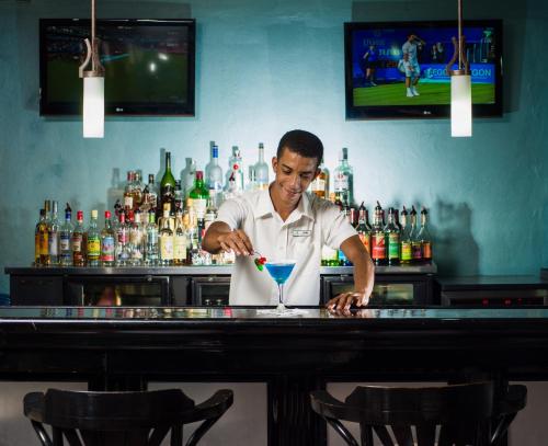 a man preparing a drink at a bar at Deja Resort All Inclusive in Montego Bay