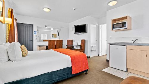 a hotel room with a bed and a kitchen at Bella Vista Motel Rotorua in Rotorua