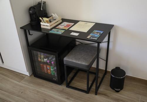 a black desk with a chair next to a wall at Affittacamere Brezza Di Sirolo in Sirolo
