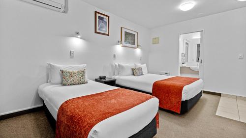 a hotel room with two beds in a room at Bella Vista Motel Rotorua in Rotorua
