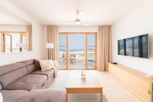 a living room with a couch and a tv at Sunset view, Los Cristianos - Port Royale in Los Cristianos