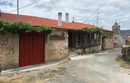 a building with a red door on a street at Casa-Museo Genia Trigo in Sober