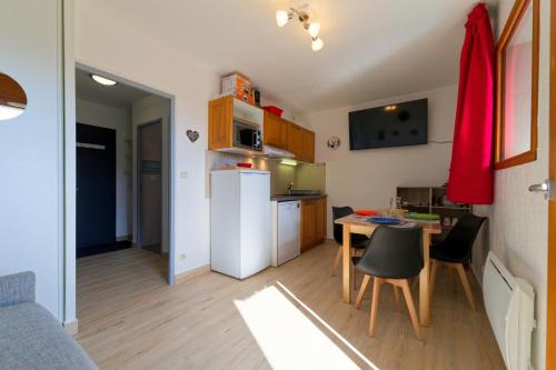 Il comprend une petite cuisine avec une table et un réfrigérateur blanc. dans l'établissement Au bon endroit N4 - Studio avec coin montagne 2 à 4 personnes - proche pistes - Belle vue, à Orcières