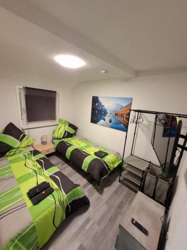 a room with two beds and a flat screen tv at GR ooms-Rent in Gemmrigheim