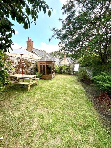 a house with a picnic table and an umbrella in a yard at Historic Rothbury Gem- West End House in Rothbury
