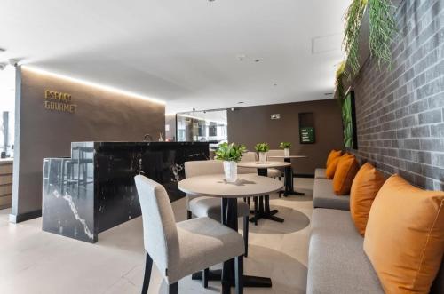 Un restaurante con mesas y sillas y una pared de ladrillos. en Alta Garden - Praia Exclusiva - Pé na areia, en João Pessoa