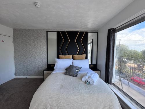 a bedroom with a large bed with a large window at Pacific Hotel in Clacton-on-Sea