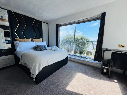 a bedroom with a large bed and a large window at Pacific Hotel in Clacton-on-Sea
