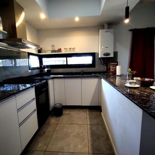 a kitchen with white cabinets and black counter tops at Funes Inn in Funes