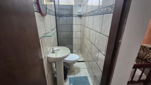 a small bathroom with a toilet and a sink at Pousada Casa Verde in Aparecida