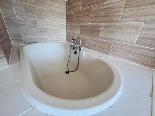a bath tub with a shower in a bathroom at Pacific Hotel in Clacton-on-Sea