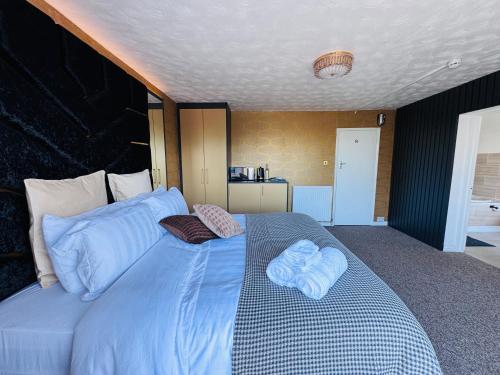 a large blue bed with two towels on it at Pacific Hotel in Clacton-on-Sea