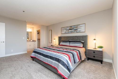 a bedroom with a bed with a striped bedspread at Stylish 2BR Apt with Rooftop Pool & Hollywood Views in Los Angeles
