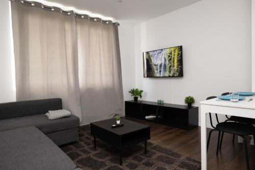 a living room with a couch and a table at Le 3 Chambres Parking Proche Tram in Clermont-Ferrand