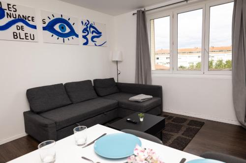 a living room with a couch and a table at Le 3 Chambres Parking Proche Tram in Clermont-Ferrand