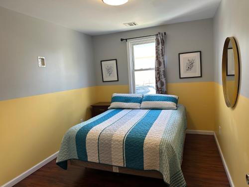 a bedroom with a bed with blue and yellow walls at JD Apartment and House in Seaside Heights