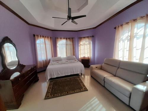 a purple room with a bed and a couch at Harmony Croft's Hill in Crofts Hill