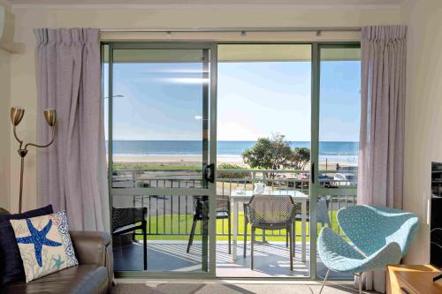 a living room with a view of the ocean at Beachpoint Apartments in Ohope Beach