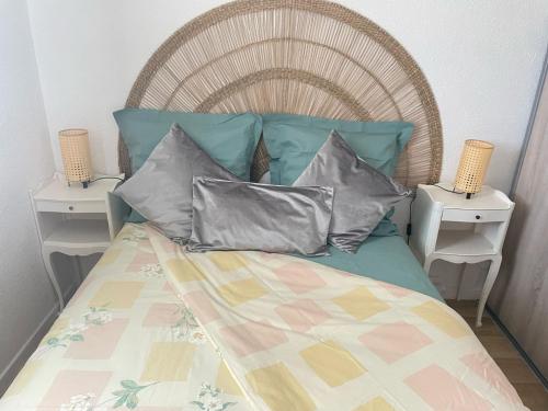 un lit avec trois oreillers dessus et deux tables de nuit dans l'établissement appartement proche mer, au Grau-du-Roi