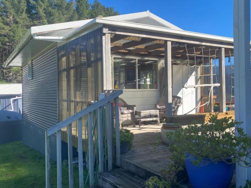 a screened in porch of a tiny house at Cosy Aotea Harbour Cottage - water views in Kawhia